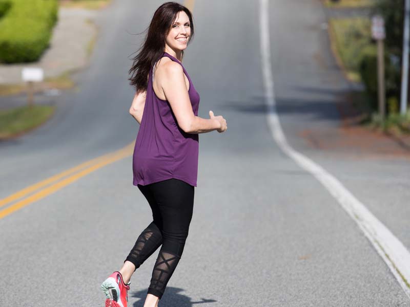 female runner running down the road in workout wear