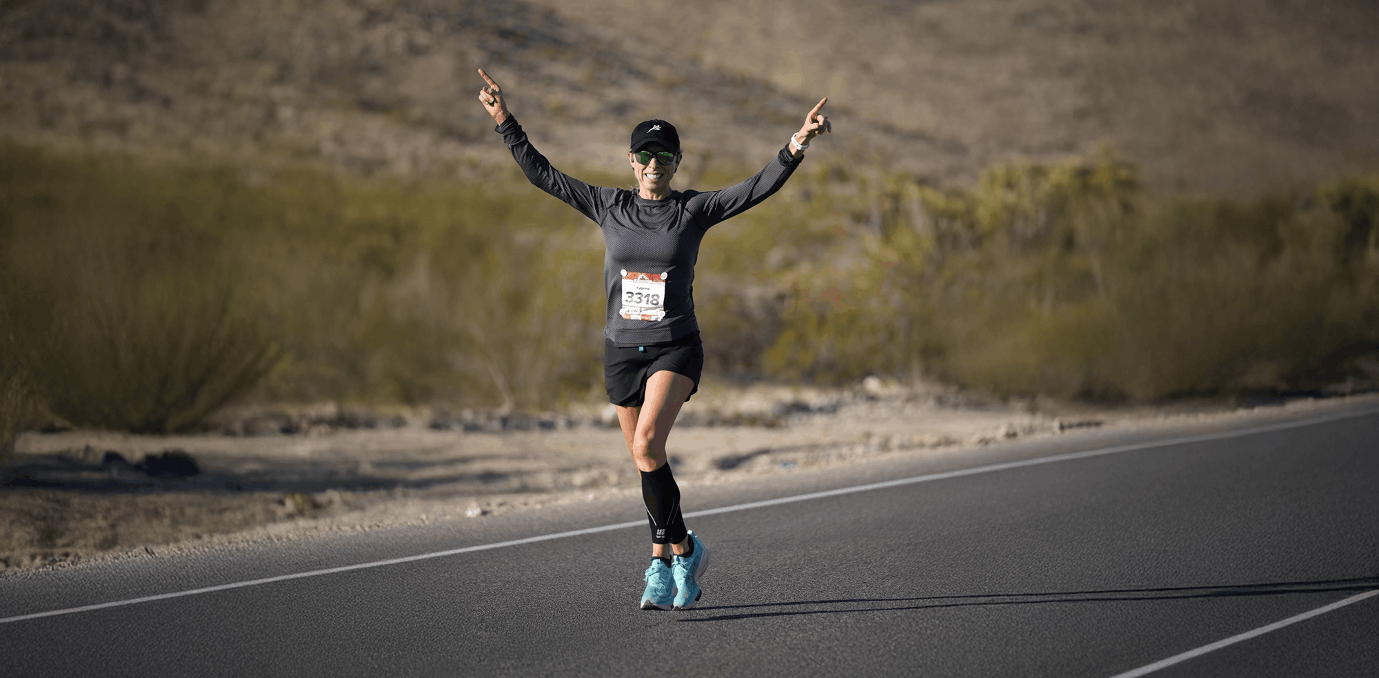 Runner in desert race hands raised