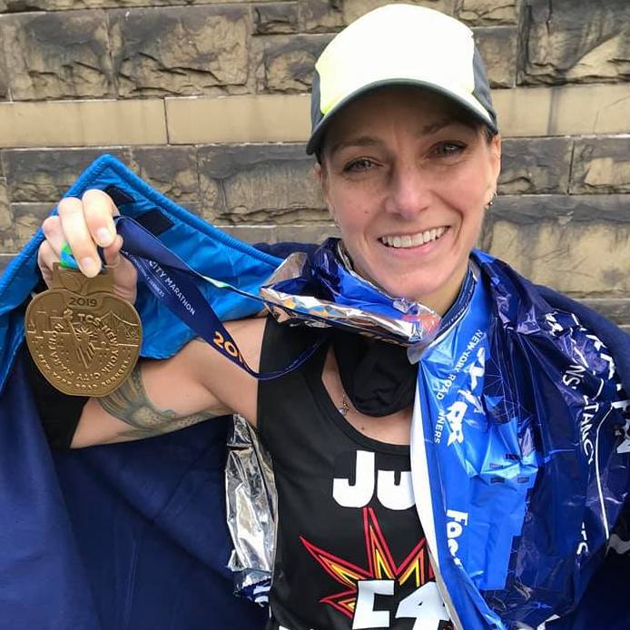Julie Dunbar smiling holding metal after running injury-free
